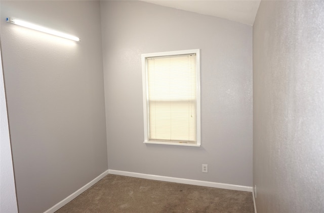 carpeted empty room with vaulted ceiling