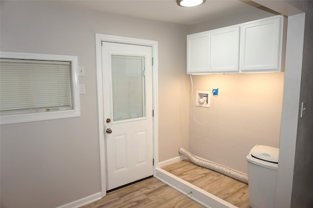 washroom with cabinets, washer hookup, and light hardwood / wood-style floors