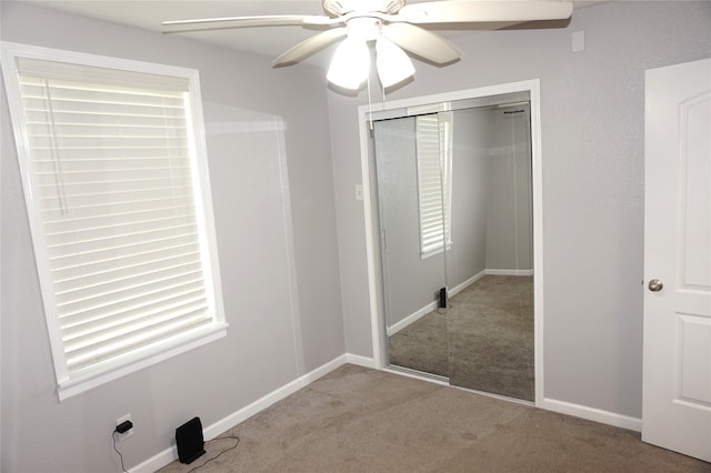 unfurnished bedroom with a closet, light colored carpet, and ceiling fan