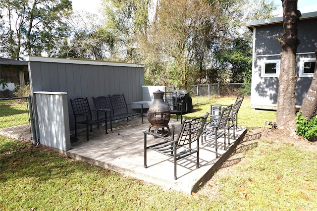 view of patio / terrace with a fire pit and a storage unit