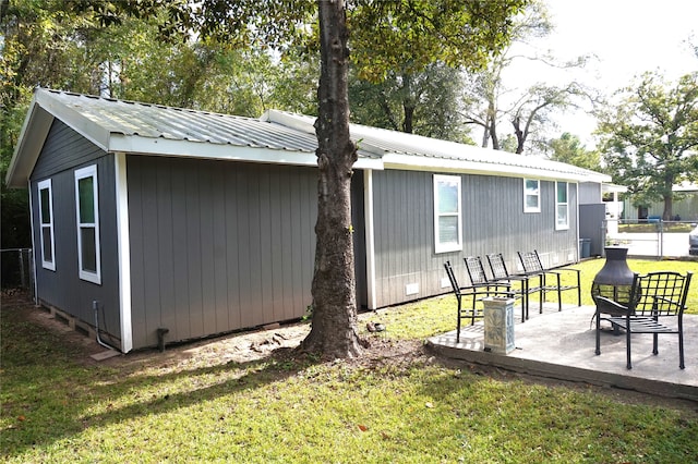 back of property with a yard and a patio