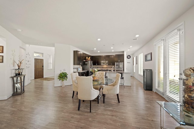 dining area with a wealth of natural light and light hardwood / wood-style flooring