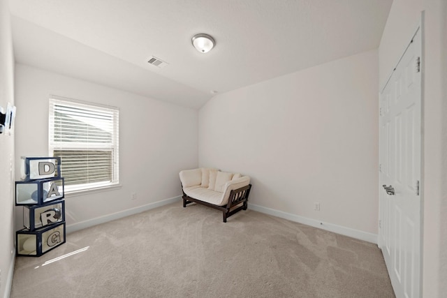 living area featuring light colored carpet and lofted ceiling