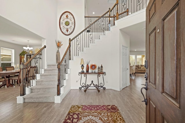 entryway with a high ceiling, light hardwood / wood-style floors, and plenty of natural light