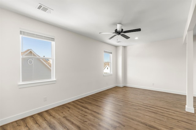 unfurnished room with ceiling fan, a healthy amount of sunlight, and wood-type flooring