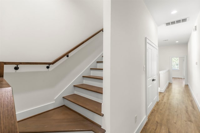 stairway with hardwood / wood-style floors