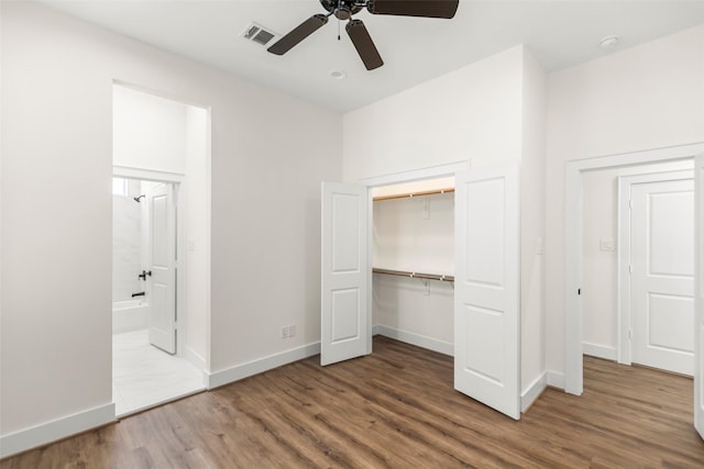 unfurnished bedroom with hardwood / wood-style floors, connected bathroom, a closet, and ceiling fan