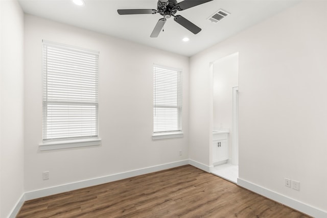 unfurnished room featuring hardwood / wood-style floors, ceiling fan, and a wealth of natural light