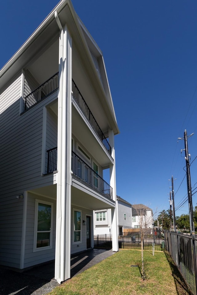 rear view of property with a yard and a balcony