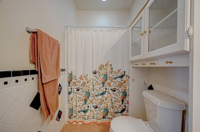 bathroom with tile walls and toilet