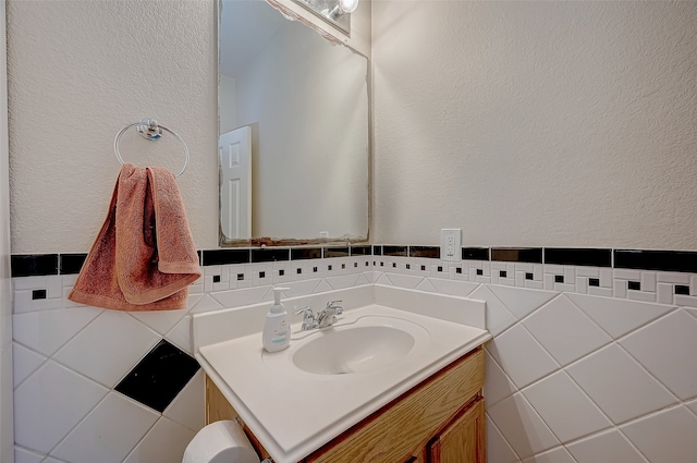 bathroom featuring vanity and tile walls