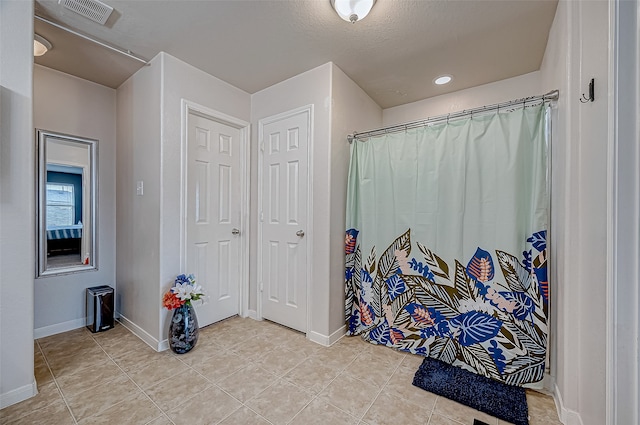 bathroom featuring tile patterned floors and a textured ceiling