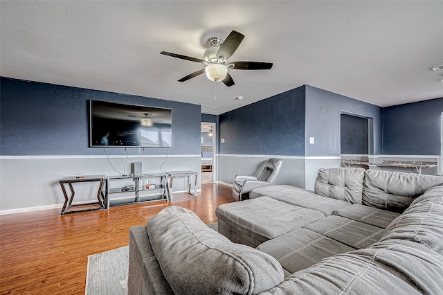 living room featuring wood-type flooring and ceiling fan