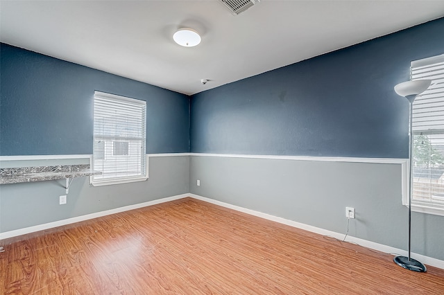 spare room featuring a wealth of natural light and light wood-type flooring