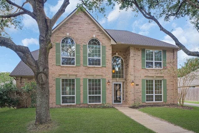 colonial-style house featuring a front yard