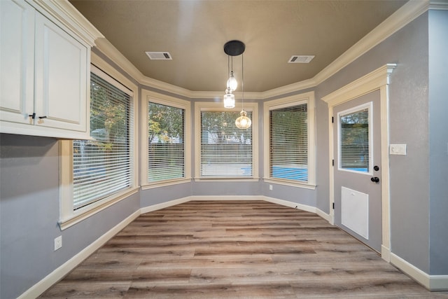 unfurnished dining area featuring light wood-type flooring and ornamental molding