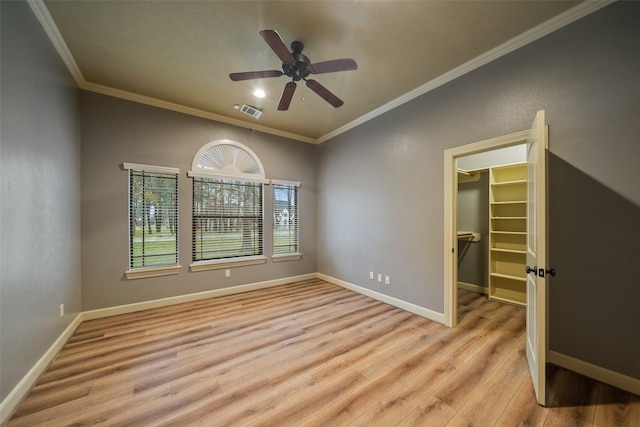 empty room featuring ceiling fan, light hardwood / wood-style floors, and crown molding