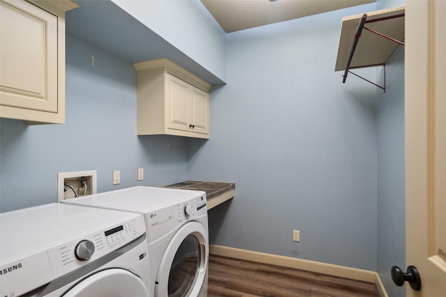 washroom featuring washer and dryer, cabinets, and dark wood-type flooring