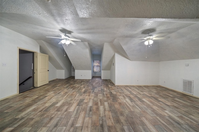 bonus room with a textured ceiling, wood-type flooring, and lofted ceiling