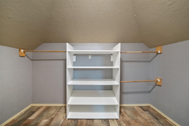 spacious closet featuring hardwood / wood-style floors and lofted ceiling