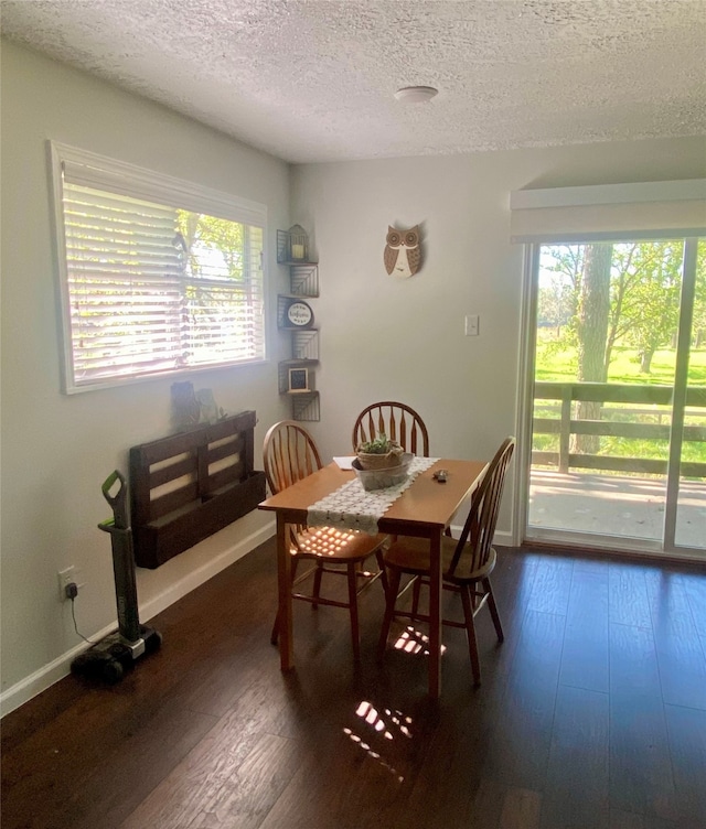 dining area featuring dark hardwood / wood-style flooring and a textured ceiling