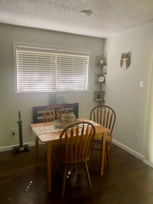 dining room featuring a textured ceiling and dark hardwood / wood-style floors