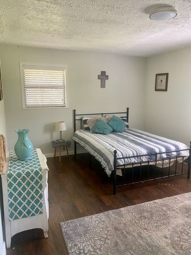 bedroom with dark hardwood / wood-style flooring and a textured ceiling