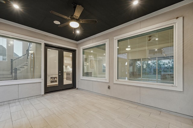 unfurnished sunroom with ceiling fan and french doors