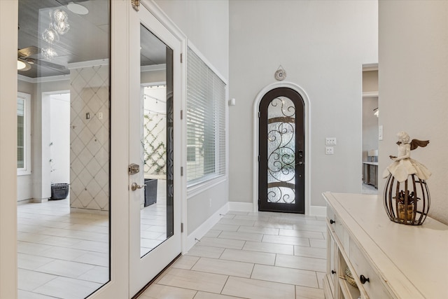 tiled foyer entrance with ornamental molding and a wealth of natural light