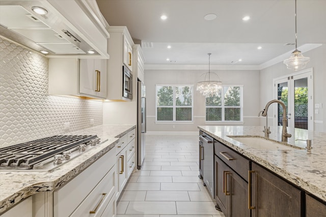 kitchen featuring premium range hood, white cabinets, sink, a healthy amount of sunlight, and stainless steel appliances