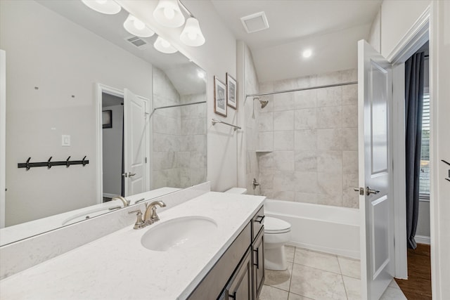 full bathroom featuring tile patterned floors, vanity, tiled shower / bath combo, toilet, and lofted ceiling