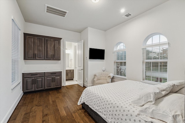 bedroom featuring ensuite bathroom and dark hardwood / wood-style flooring