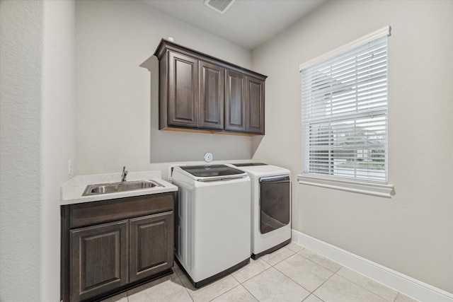 laundry room with cabinets, light tile patterned flooring, washer and clothes dryer, and sink