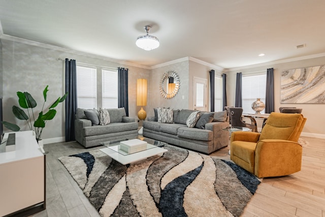 living room with a healthy amount of sunlight, light hardwood / wood-style floors, and ornamental molding