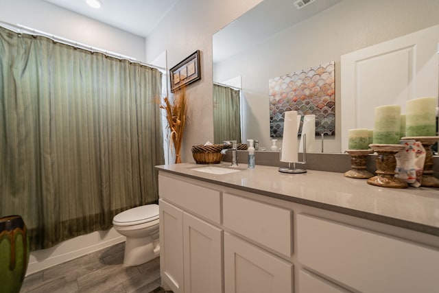 full bathroom featuring shower / bath combo with shower curtain, vanity, wood-type flooring, and toilet