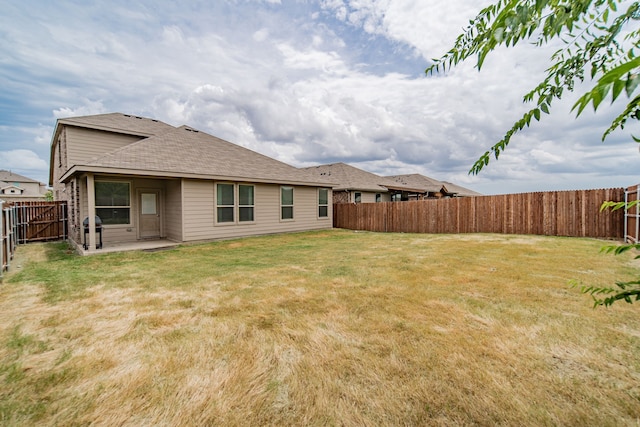 rear view of house featuring a yard