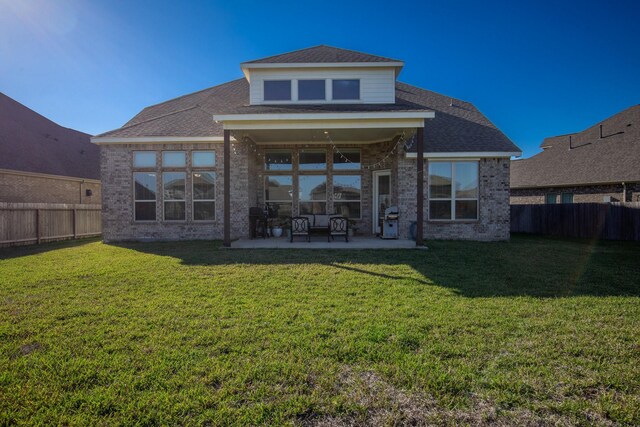 back of house with a lawn and a patio area