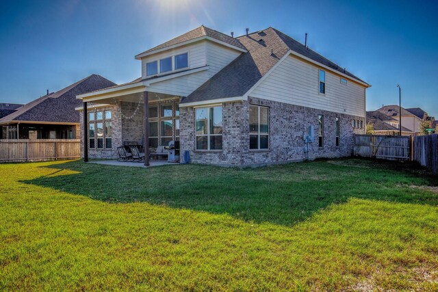 back of house featuring a yard and a patio