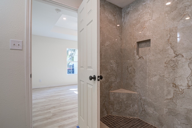 bathroom with hardwood / wood-style floors and tiled shower