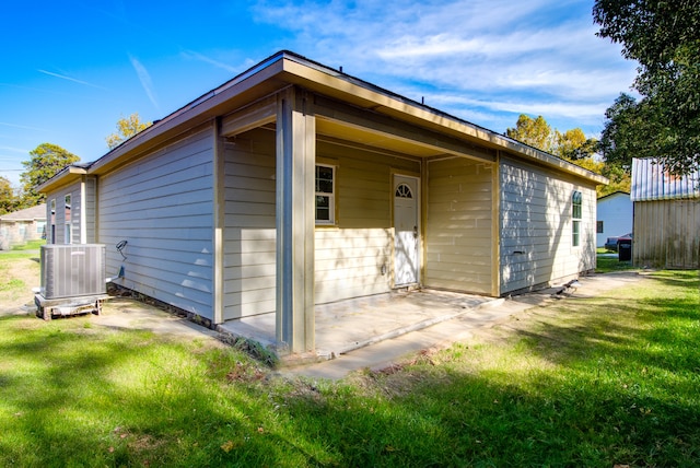 back of house with a lawn, cooling unit, and a patio