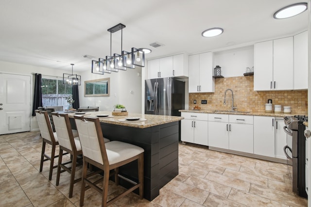 kitchen with a center island, white cabinetry, and sink