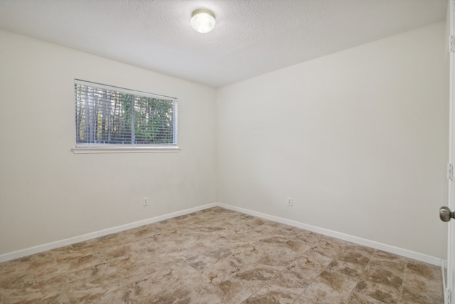 unfurnished room featuring a textured ceiling