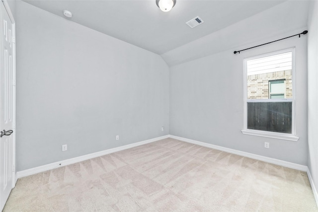 unfurnished room with light carpet and lofted ceiling