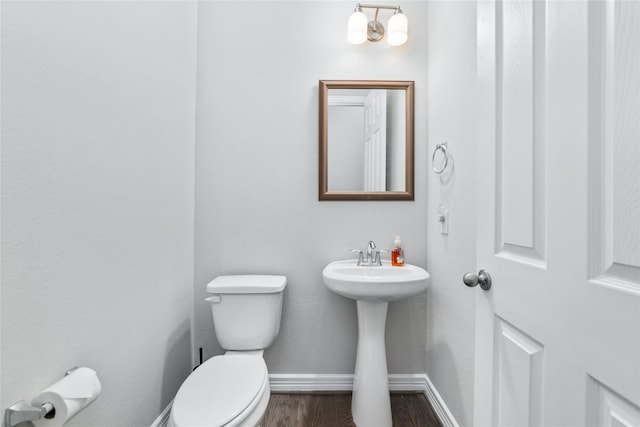 bathroom with sink, hardwood / wood-style floors, and toilet