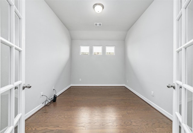 spare room with french doors, dark wood-type flooring, and vaulted ceiling