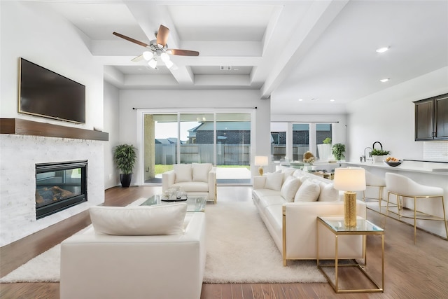 living room with ceiling fan, sink, and light hardwood / wood-style floors