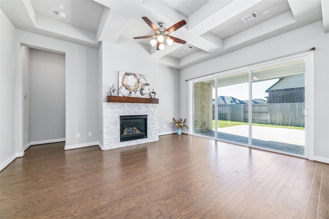 unfurnished living room featuring ceiling fan, dark wood-type flooring, coffered ceiling, beamed ceiling, and a fireplace