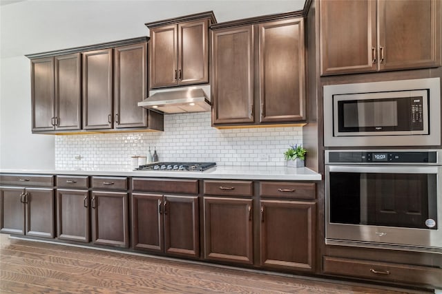 kitchen with dark brown cabinetry, dark wood-type flooring, and appliances with stainless steel finishes