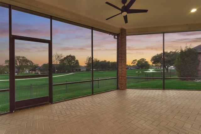 unfurnished sunroom with ceiling fan