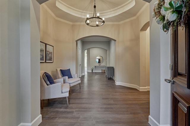 interior space featuring a chandelier, ornamental molding, dark hardwood / wood-style floors, and a tray ceiling